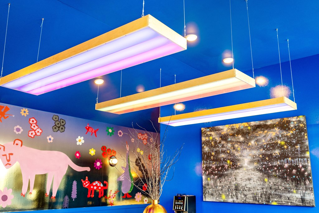 a blue room with neon lights hanging from the ceiling and pictures of christmas decorations