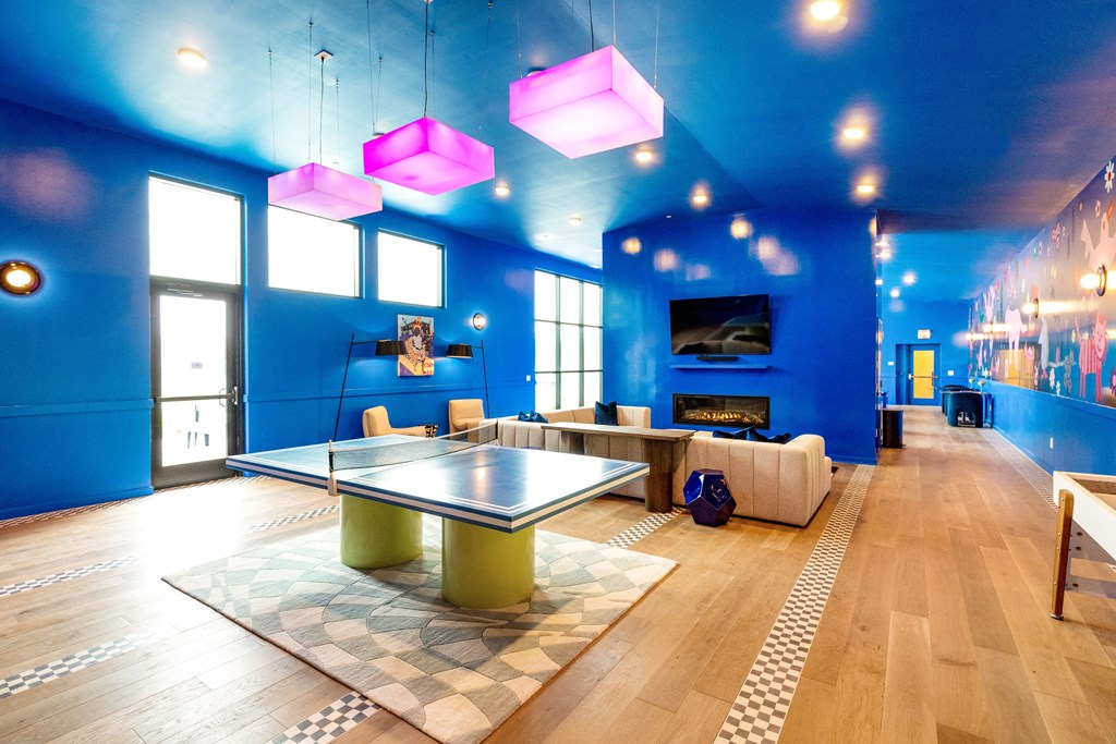 a game room with blue walls and a ping pong table