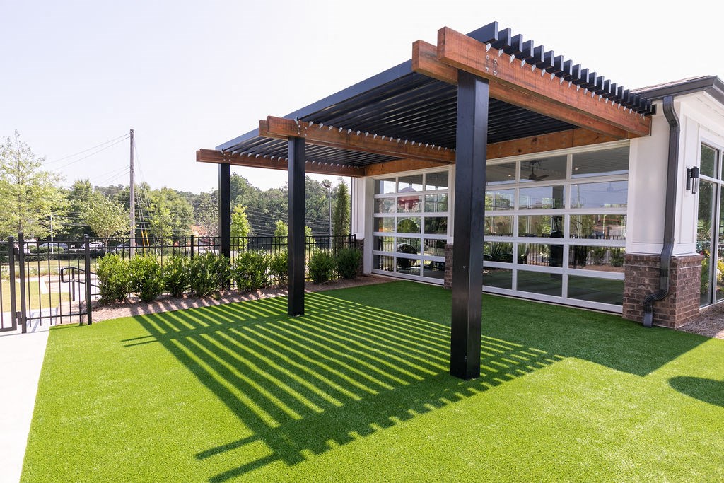 a pergola on a lawn in front of a building