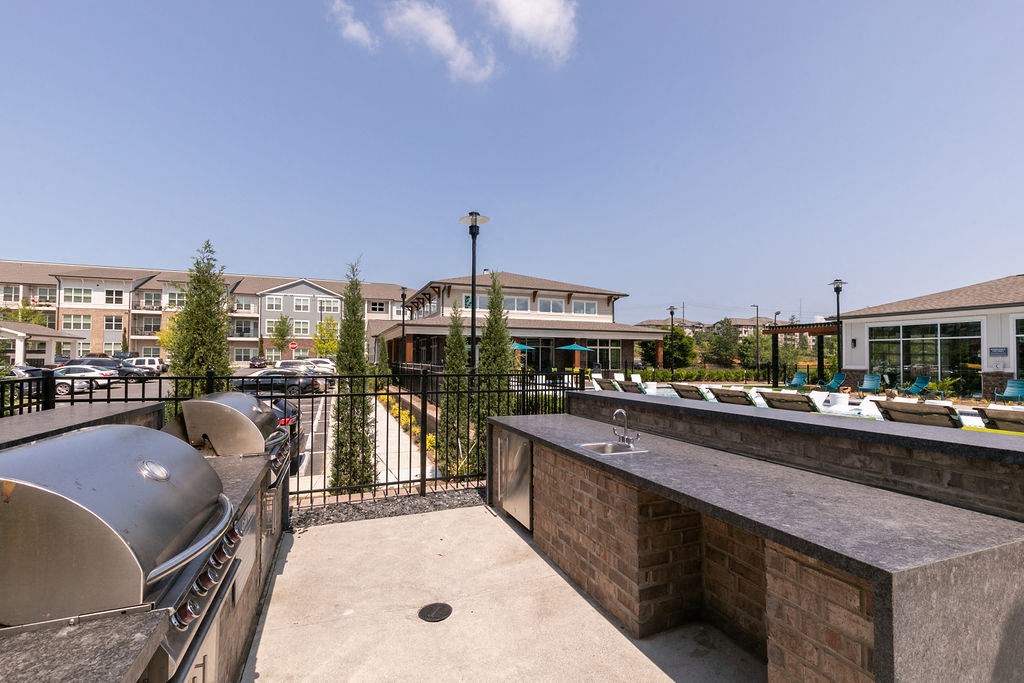 a patio with a sink and a fenced in area with buildings in the background