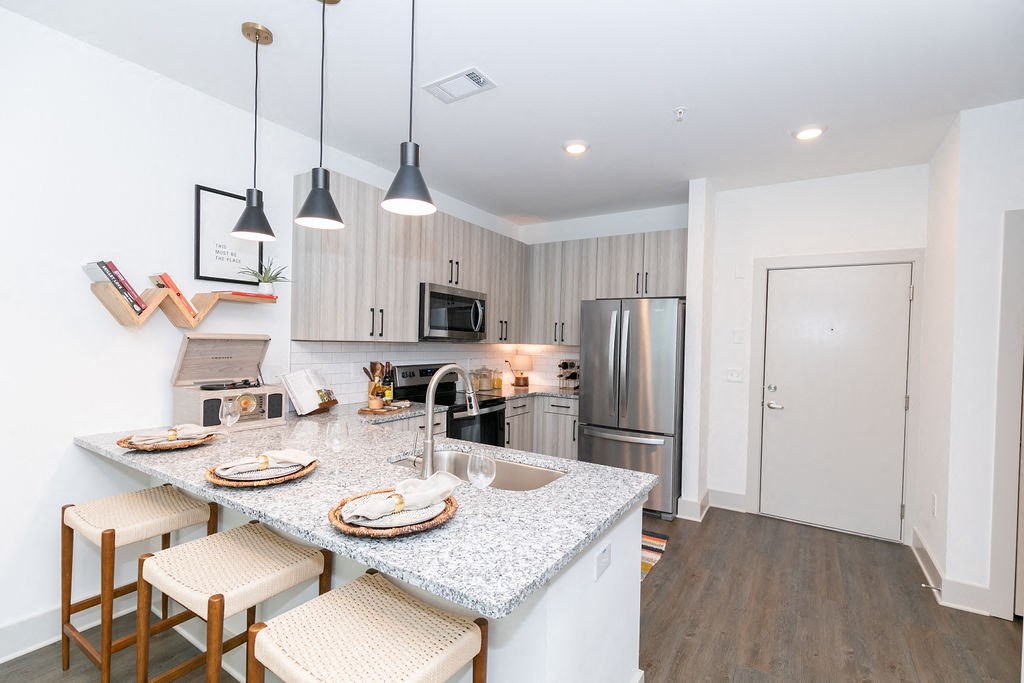 a kitchen with a marble counter top and stainless steel appliances