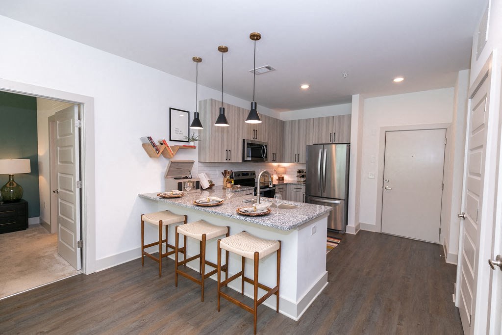 a kitchen with an island and stools in a living room