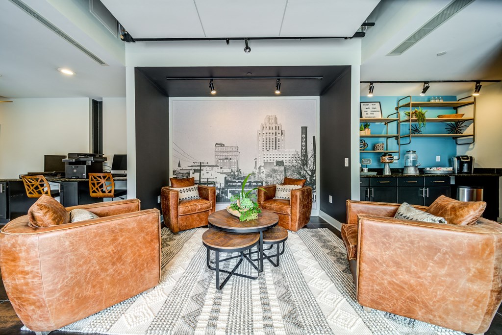 a living room with leather furniture and a mural on the wall