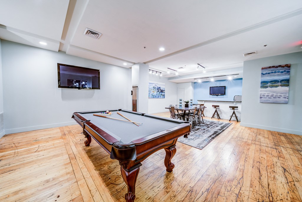 a game room with a pool table and a tv