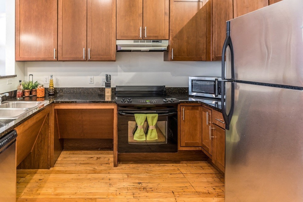 a kitchen with wooden cabinets and stainless steel appliances
