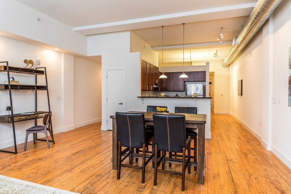 a dining room and kitchen with a wooden table and chairs