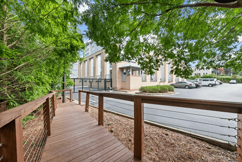 A wooden walkway leads through a green area.