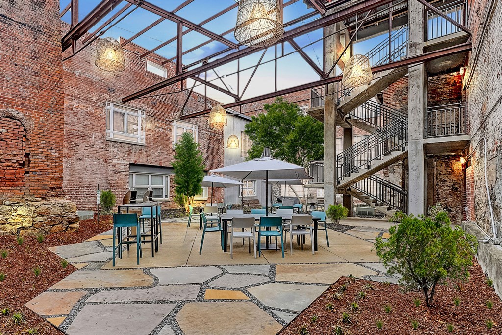 a courtyard with tables and chairs and a glass ceiling
