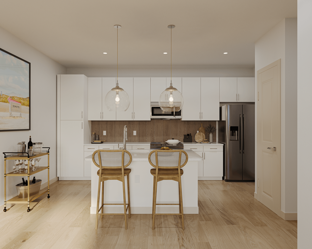 a kitchen with white cabinets and a white island with two bar stools