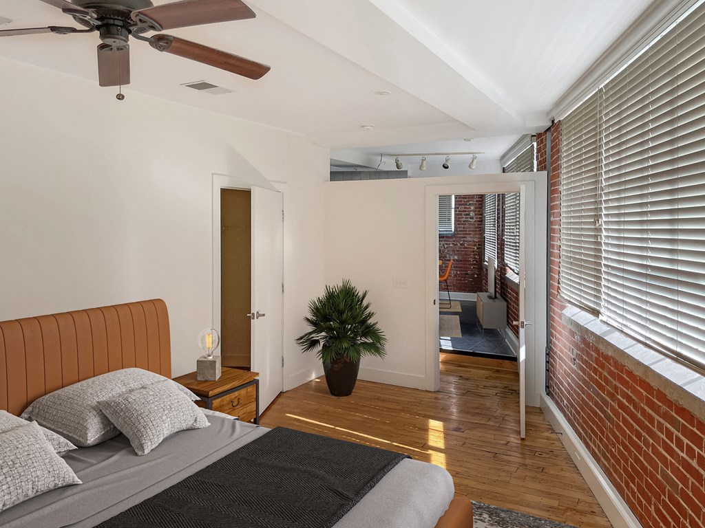 a bedroom with a bed and a ceiling fan     and a bathroom