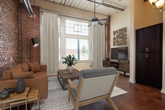 a living room with a brick wall and a large window - Photo Gallery