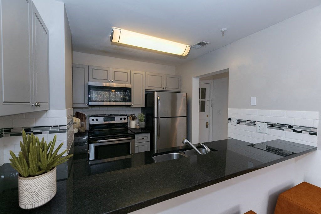 a kitchen with stainless steel appliances and black counter tops