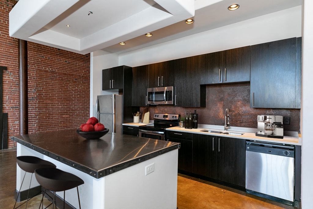 a modern kitchen with black cabinets and a counter top