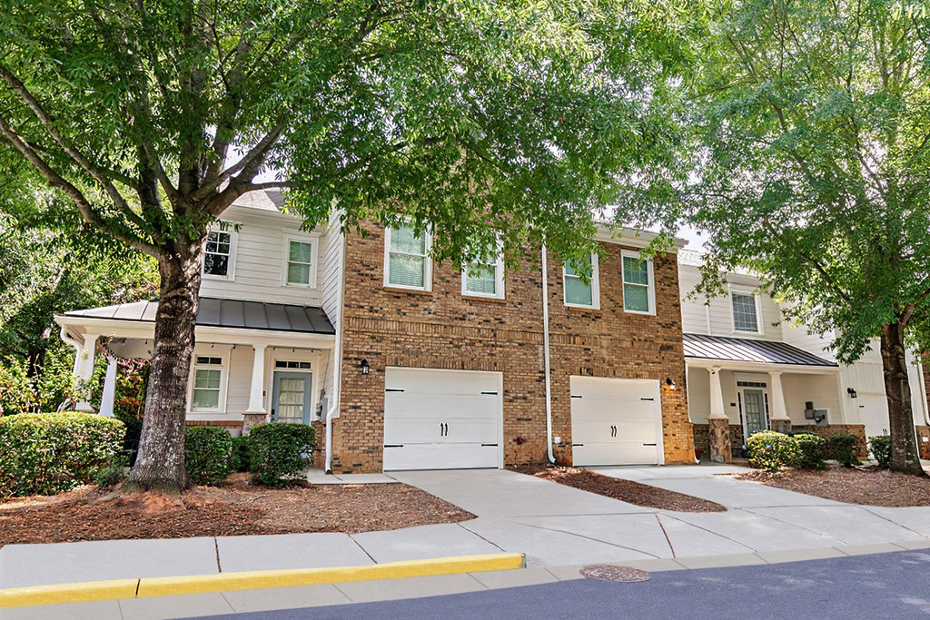 a house with white doors and trees in front of it