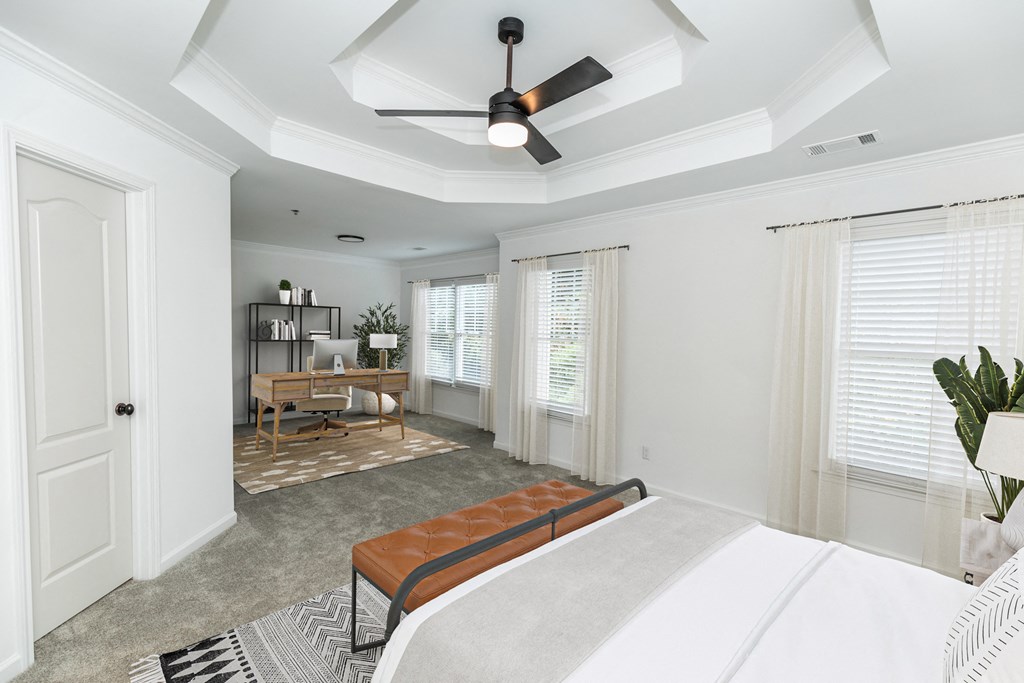 a bedroom with a large bed and a ceiling fan