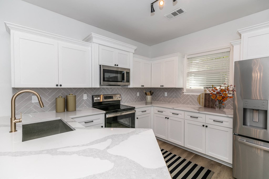 a kitchen with white cabinets and stainless steel appliances