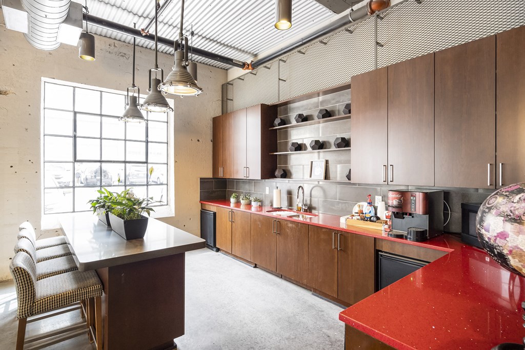 a kitchen with a red counter top and a large window