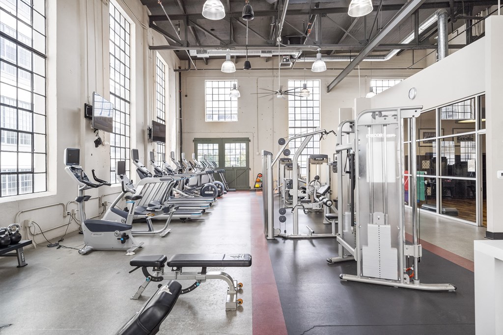 a fitness room with cardio machines and weights
