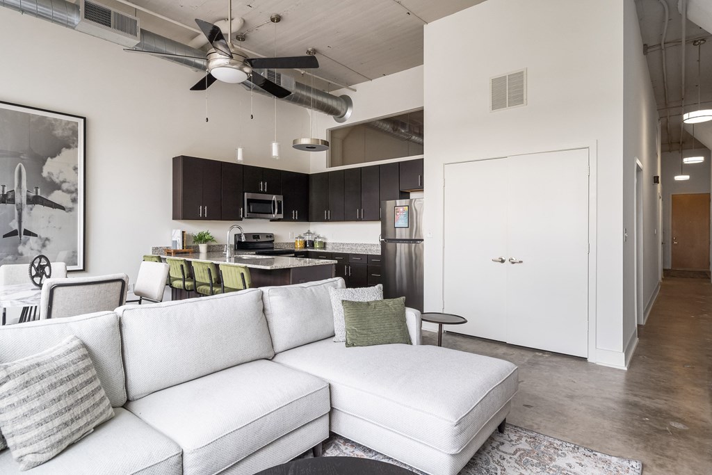 a living room with a white couch and a ceiling fan