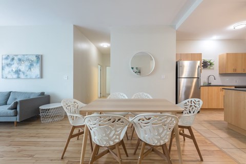 A modern dining room with a wooden table and chairs.