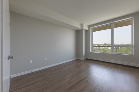 A room with a wooden floor and a large window.