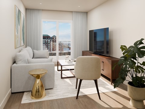 A modern living room with a grey sofa, a white chair, a gold stool, and a television.