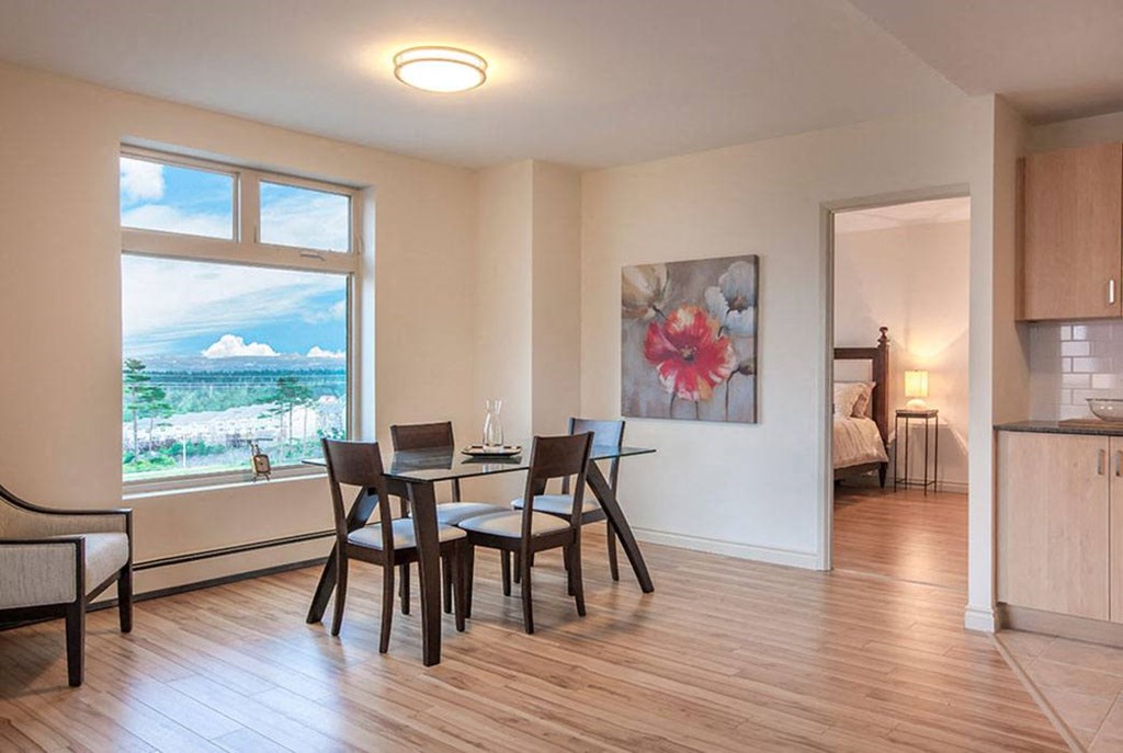 a dining room with a table and chairs and a window