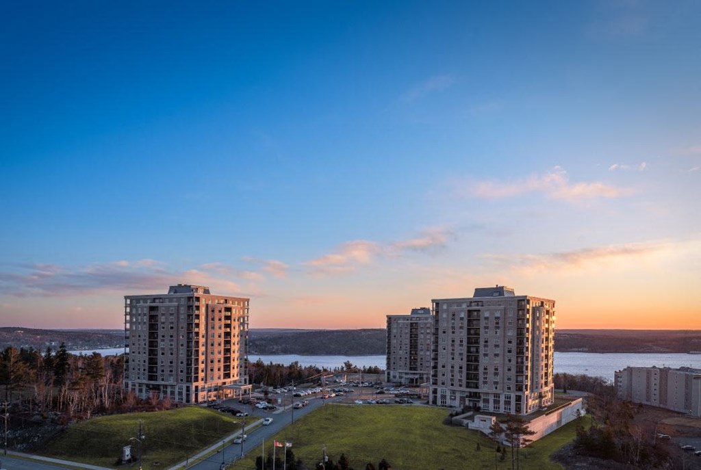 a city skyline at sunset with the water in the background