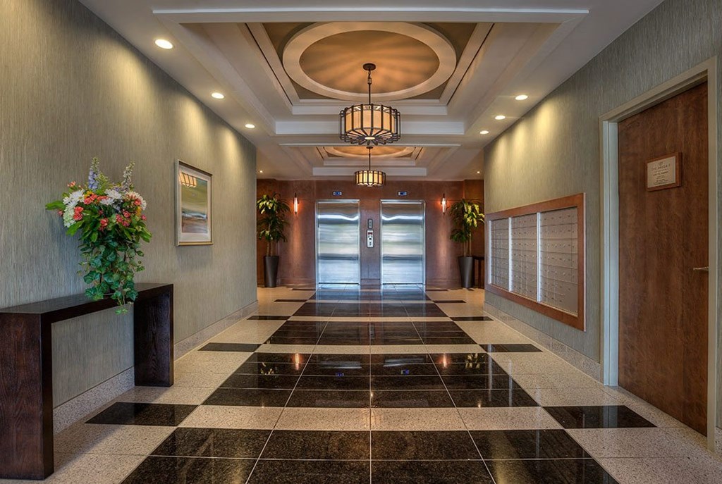 the lobby of a building with doors and a chandelier