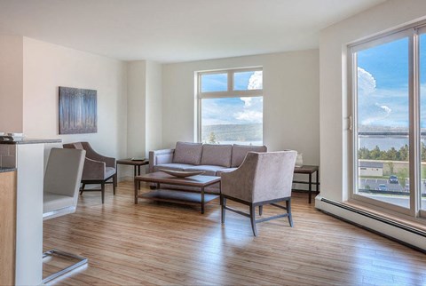 a living room with a couch and chairs and a large window