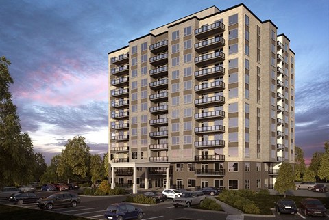 A large apartment building with a parking lot in front.
