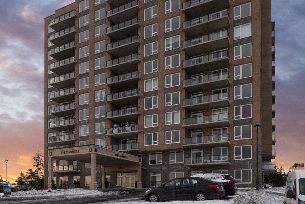 a tall apartment building with cars parked in front of it