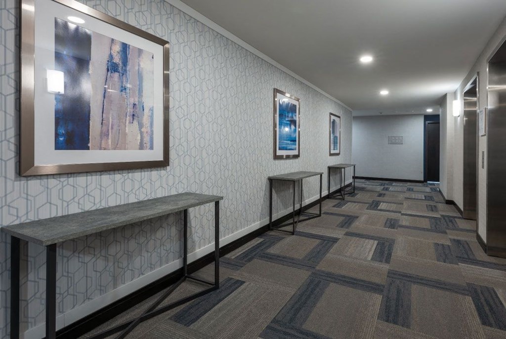 a hallway with artwork and benches in a building