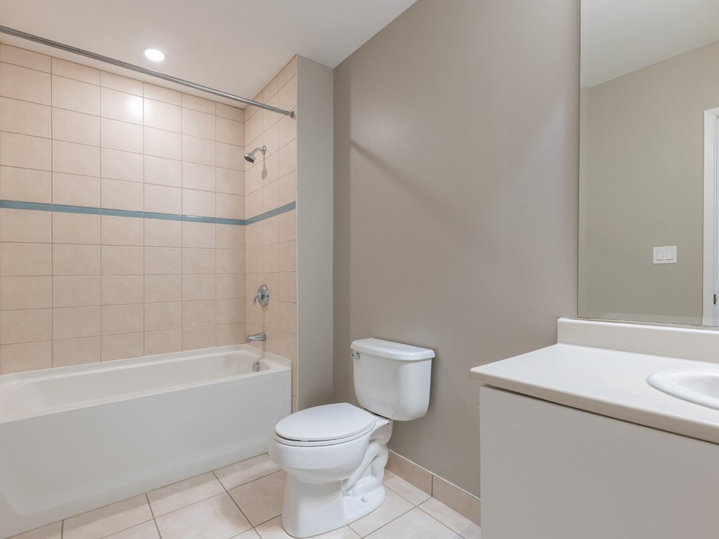 A white toilet sits next to a bathtub in a bathroom.