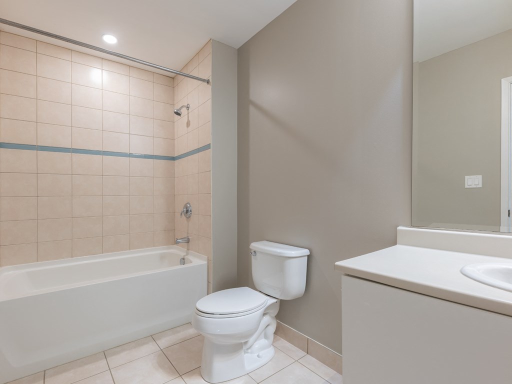 A white toilet sits next to a bathtub in a bathroom.