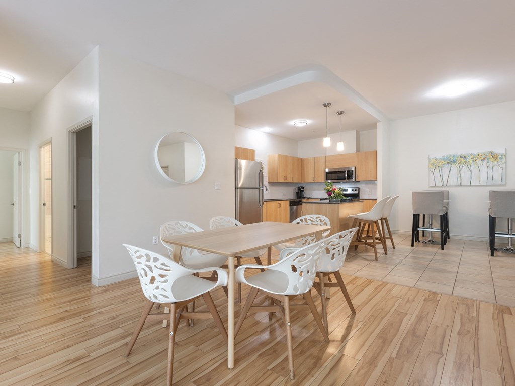 A modern dining room with a wooden table and chairs.