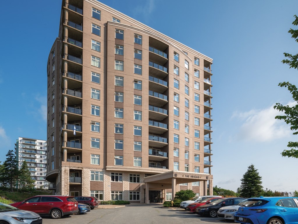 A large apartment building with a parking lot in front.