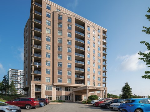 A large apartment building with a parking lot in front.