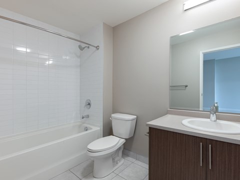 A white toilet sits next to a bathtub in a bathroom.