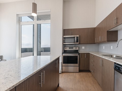 A modern kitchen with wooden cabinets and stainless steel appliances.