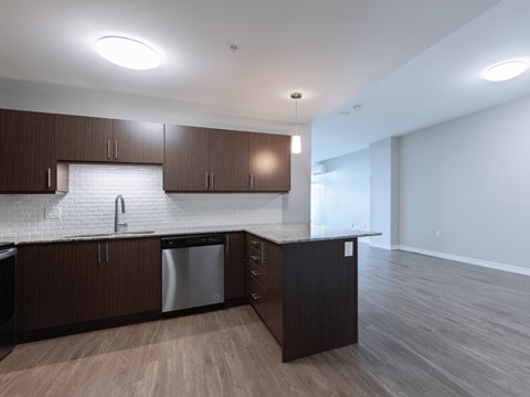 A kitchen with dark wood cabinets and a white backsplash.