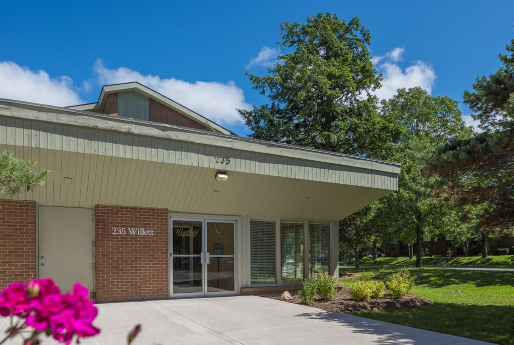 a building with a glass door and a sidewalk in front of it
