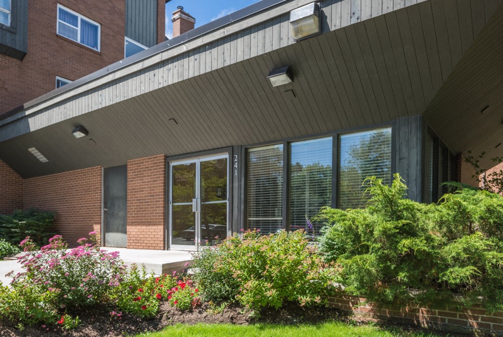 the front of a brick building with large windows