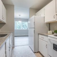 a kitchen with white cabinets and a sink and a refrigerator