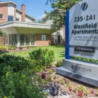 a sign for the apartments is in front of a house