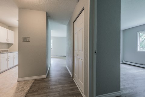 an empty kitchen and hallway with a door open to the living room
