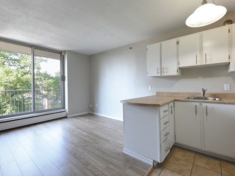 A kitchen with white cabinets and a wooden countertop.