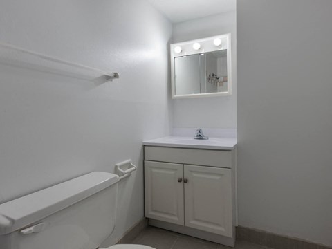 A white bathroom with a toilet, sink, and medicine cabinet.