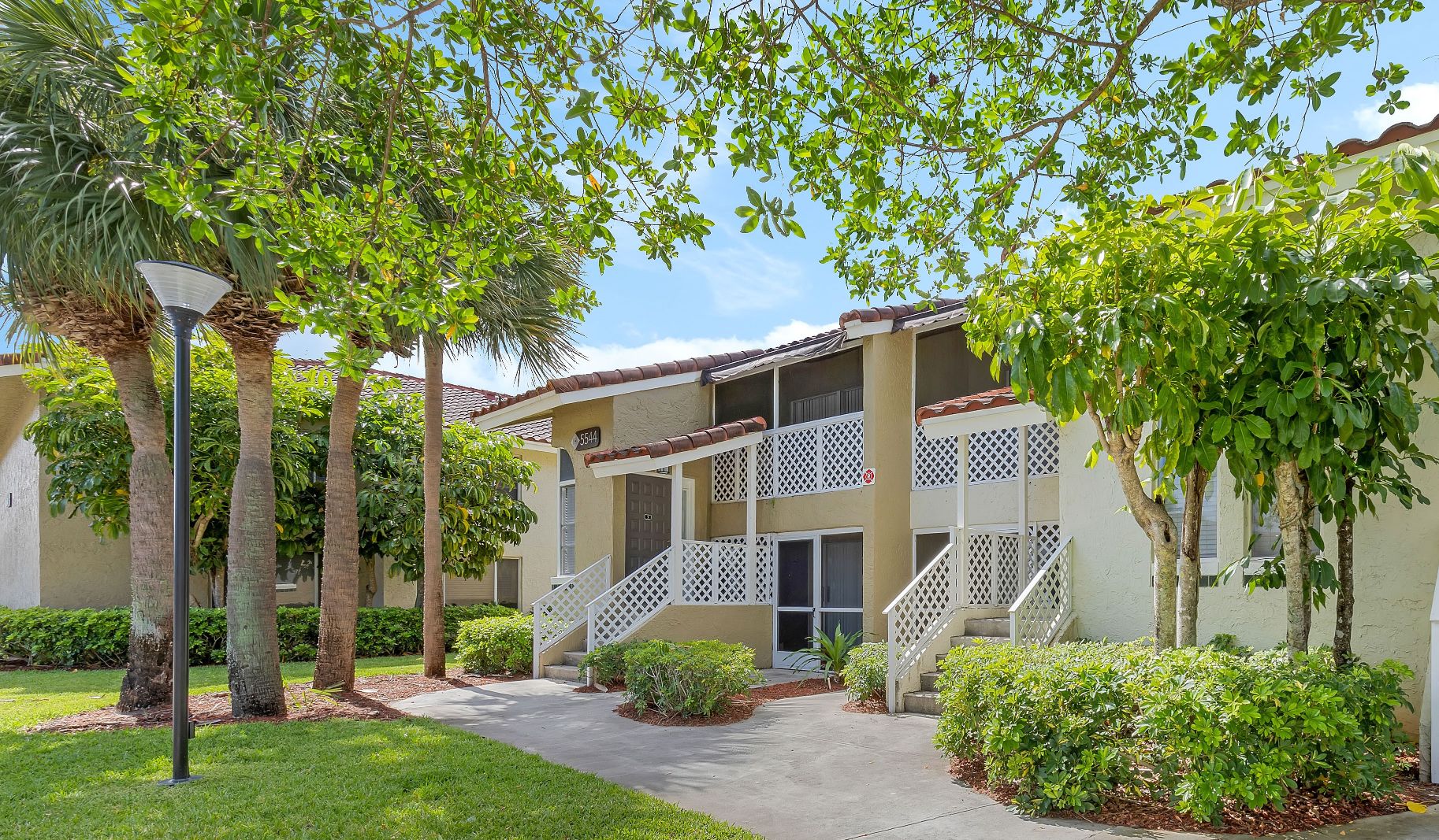 a building with trees and a sidewalk in front of it