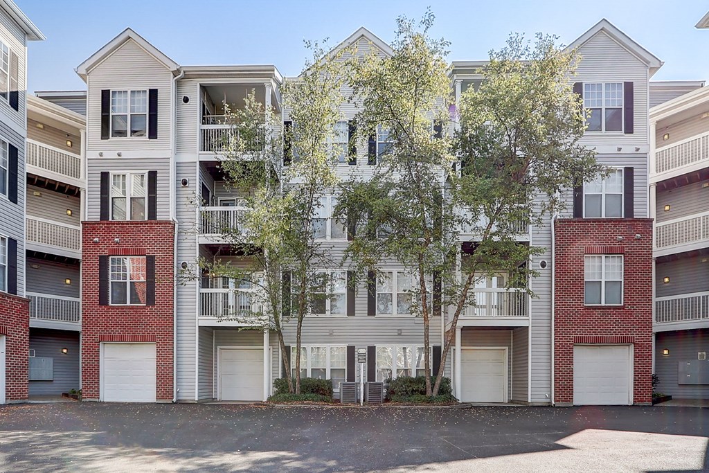 an exterior view of an apartment building with trees in front of it